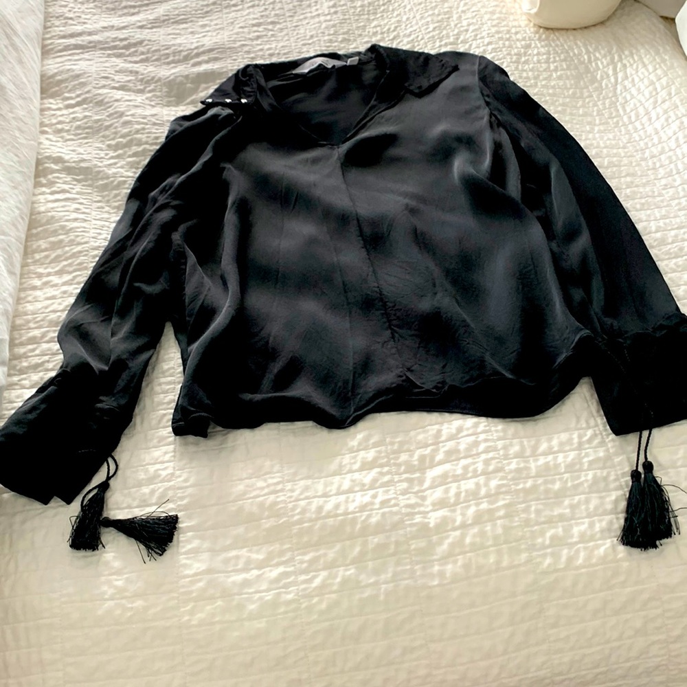 Edgy, black top with beautiful tassels at each cuff.